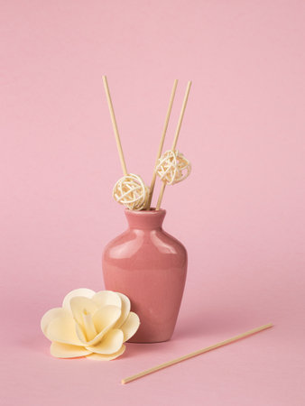 An elegant vase with incense sticks on a pink background. The minimal concept of creating fragrances.の写真素材