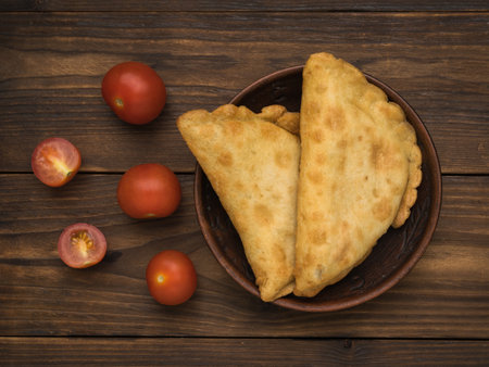 Two pies and cherry tomatoes on a wooden table. The minimum concept of bakery products with meat.の写真素材