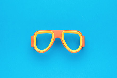 Yellow-orange diving mask on a blue background. An accessory for scuba diving. Flat lay.の写真素材