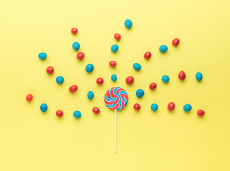 Flying red and blue candies from a lollipop. The concept of sweets. Flat lay.の写真素材