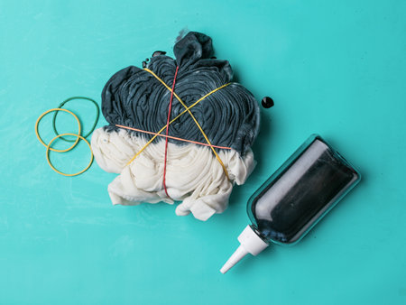 Coloring a T-shirt in black in tie dye style. The process of painting in the style of tie dye. Flat lay.の写真素材