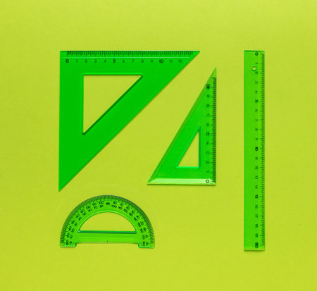 A set of green rulers on a green background. The concept of science and education.の写真素材