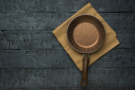 Top view of a frying pan with a towel on a wooden table. Cooking utensils. Flat lay.の写真素材