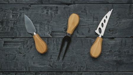 Three small cheese knives on a wooden background. Flat lay.の写真素材