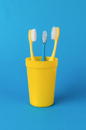 Blue and two yellow toothbrushes on a blue background. The concept of oral care.の写真素材