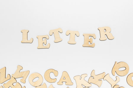 Lettering letter and wooden letters on a white background. A set for studying writing.の写真素材