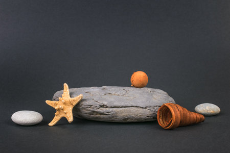 Stone pedestal with accessories on a gray background. The concept of presentation of a cosmetic product.の写真素材