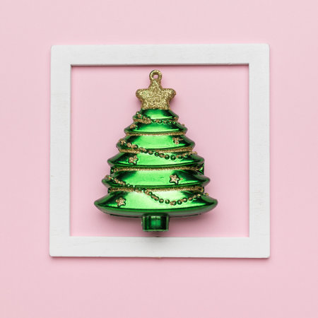 Christmas tree decoration in a white frame on a pink background. The concept of the New Year and Christmas.の写真素材