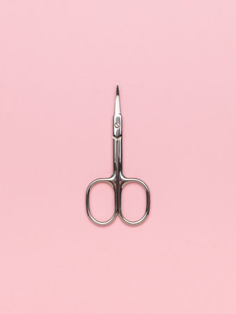 Metal nail scissors on a light pink background. A place for your text.の写真素材