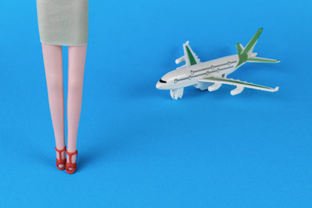 Women's legs and a plane on a blue background. The concept of wires and meetings.