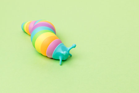 A multi-colored caterpillar toy crawling on a green background. Antistress toy.の写真素材