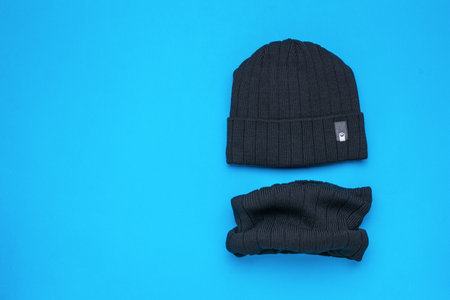 A black scarf with a black hat on a blue background. Men's headdress.