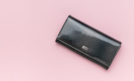 Dark women's purse on a pink background. A place for your text.の写真素材