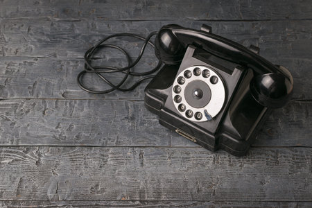 Vintage classic phone on a wooden background. Vintage equipment.