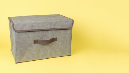 Gray cloth storage box on a yellow background. The concept of storing things.の写真素材