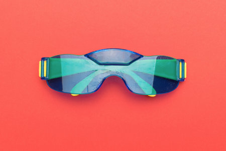 Bright blue and yellow glasses on a red background. A fashion accessory.