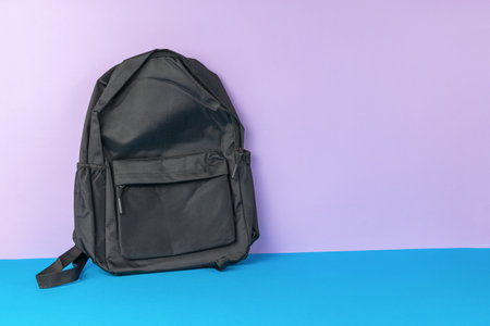 A black backpack on a two-tone background. Universal shoulder bag.の写真素材