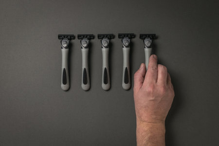 The man takes one of the five razors in the set. The concept of facial hygiene.の写真素材