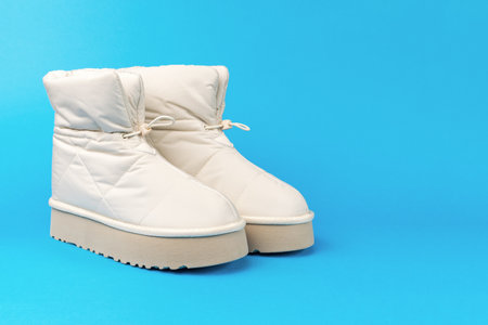 A pair of short beige women's shoes on a blue background. Women's shoes for cold weather.の写真素材