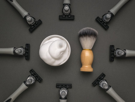 Shaving foam and a shaving brush surrounded by several razors. The concept of facial hygiene.の写真素材