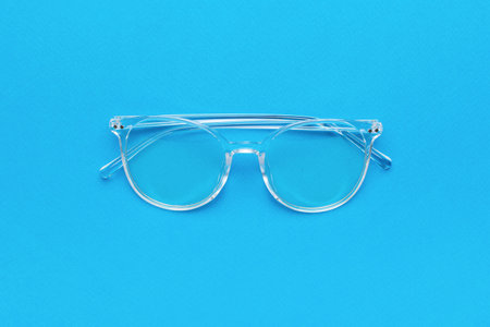 Transparent women's stylish glasses on a blue background. A fashionable tool for vision correction.の写真素材