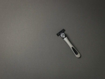 Men's gray razor on a gray background. The concept of facial hygiene.の写真素材