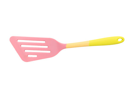 Silicone pink and yellow shoulder blade isolated on a white background. Creative kitchen utensils.の写真素材