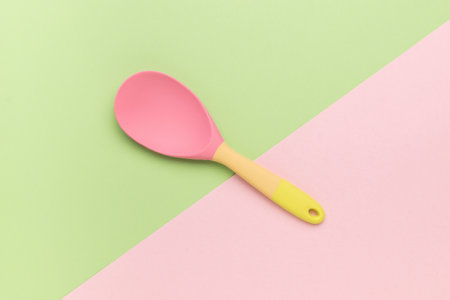 A beautiful silicone spoon on a two-tone background. Creative kitchen utensils.の写真素材