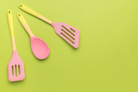 Multicolored kitchen set on a bright green background. Creative kitchen utensils.