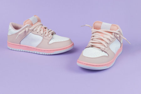 Original red and white sneakers on a purple background. Stylish sports shoes.の写真素材