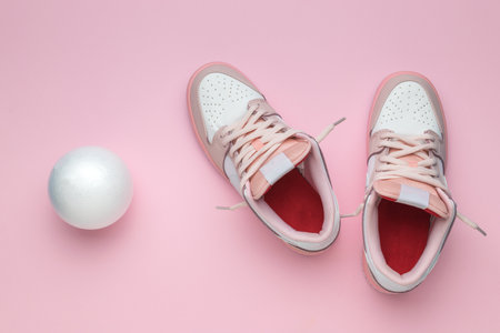 Top view of pink and white sneakers and a white balloon on a pink background. Stylish sports shoes.の写真素材