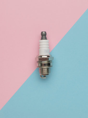 A short spark plug on a pink and blue background. Part of an internal combustion engine.
