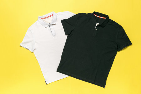 White and Black Polo Shirts on Yellow Background - Fashion Apparel in Minimalist Designの写真素材