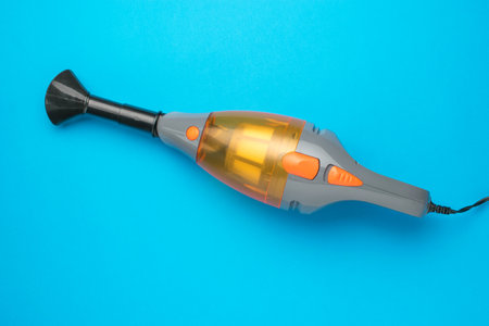 Handheld Vacuum Cleaner on Blue Background - Modern Design for Efficient Cleaning