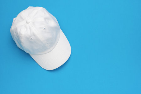 White Baseball Cap on Blue Background: Minimalist Fashion Accessory Stock Photoの写真素材