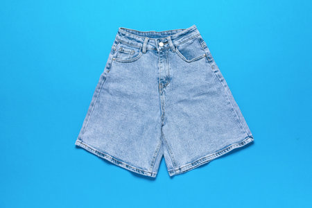Vintage Light Blue Denim Shorts on Vibrant Blue Backgroundの写真素材