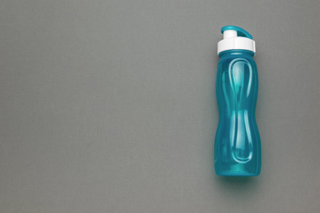 Reusable Blue Plastic Water Bottle with White Cap on Gray Backgroundの写真素材