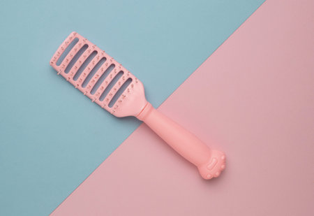 Pink Hairbrush on Blue and Pink Background - Minimalist Beauty and Styling Toolの写真素材