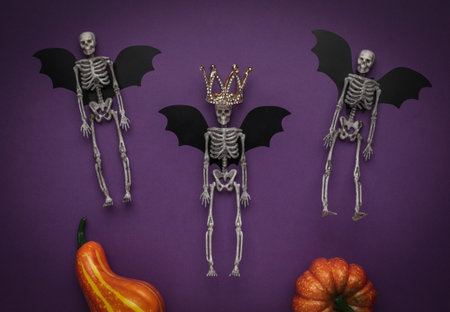 Halloween Skeleton Bats with Crown and Pumpkins on Purple Backgroundの写真素材