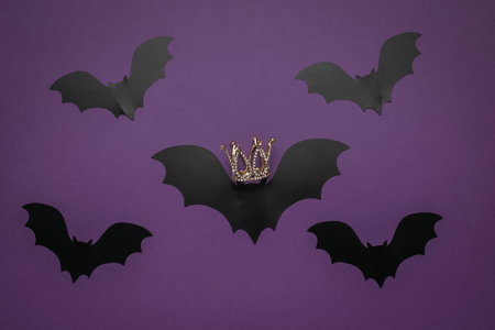 Crowned Bat Leader Among Flying Bats on Purple Backgroundの写真素材