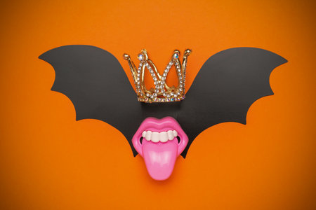 Creative Halloween Crowned Bat with Pink Mouth and Orange Backgroundの写真素材
