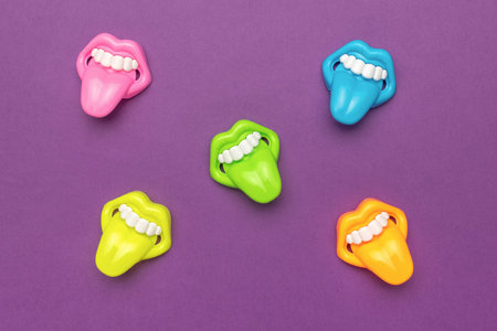 Colorful Plastic Teeth and Tongues Toys on Purple Backgroundの写真素材