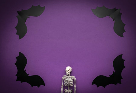 Skeleton Surrounded by Paper Bats on Purple Background for Halloween Decoration
