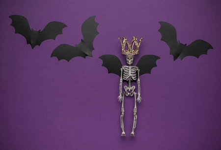 Skeleton with Crown and Bat Wings on Purple Backgroundの写真素材