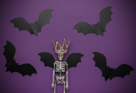** Skeleton with Crown and Bat Wings on Purple Background - Halloween Royaltyの写真素材