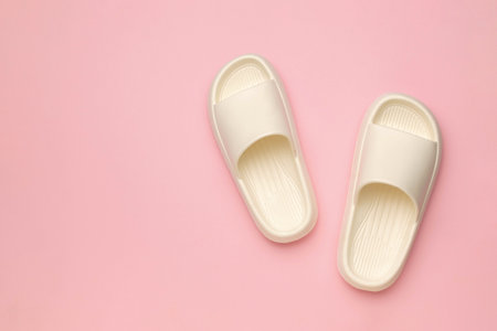 Minimalist White Slip-on Sandals on Pink Background Summer Footwear Fashion Conceptの写真素材