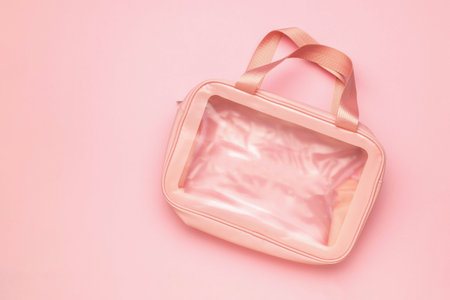Transparent Pink Cosmetic Bag on Pastel Pink Background - Minimalist Travel Organizerの写真素材