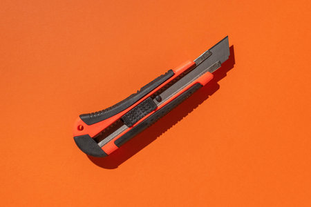 Orange Retractable Utility Knife on Vibrant Background Highlighting Modern Tool Designの写真素材