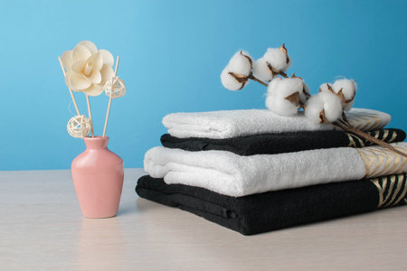 Minimalist Spa Decor with Stacked Towels, Cotton Flowers, and Aromatic Reed Diffuserの写真素材