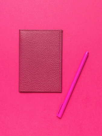 Vibrant Pink Notebook and Pen on a Bold Pink Background - Minimalist Office Suppliesの写真素材